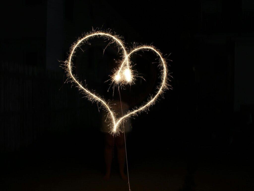 Performer creating a heart shape with a sparkler.