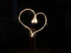Performer creating a heart shape with a sparkler.
