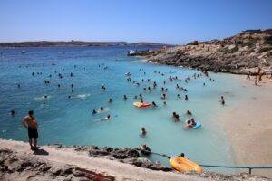 People standing in the sea at Hondoq beach.
