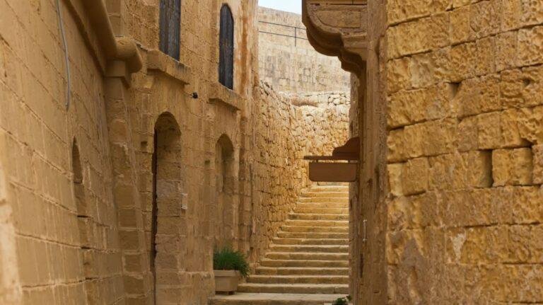 Steps lead up between tall limestone buildings in the Victoria Citadel.