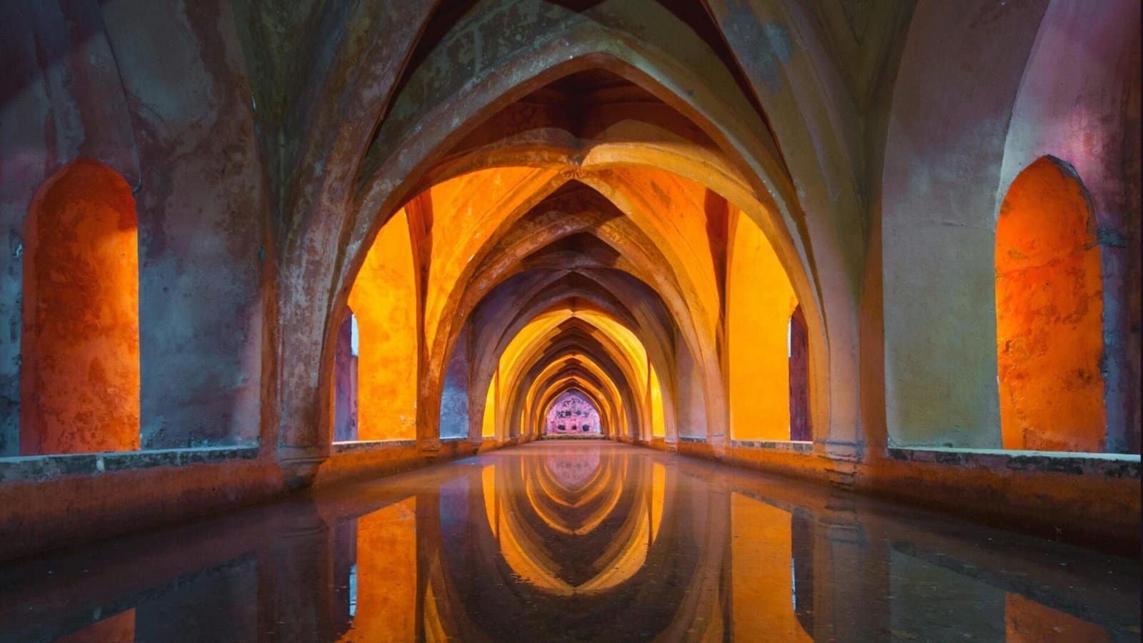 Arches of a church, beautifully reflected in the polished floor.