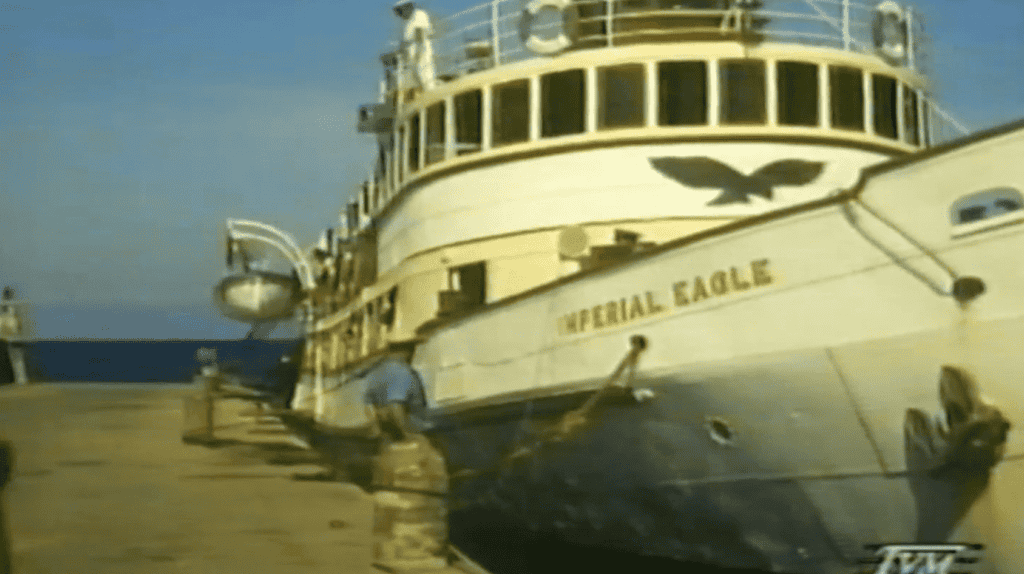 A large white boat at a dock.