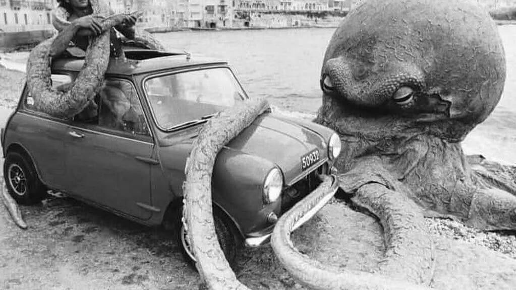 A giant octopus has wrapped a tentacle on an original Mini.