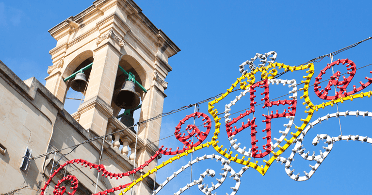 A church bell tower with festa lights for St George's Festa.