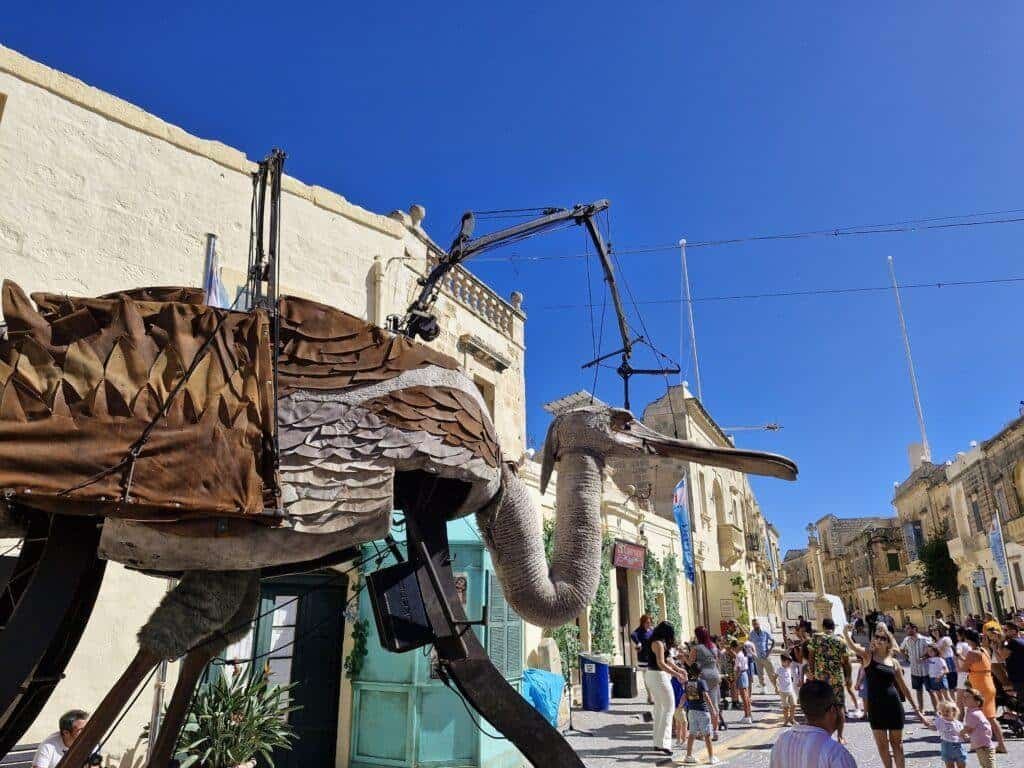 A giant mechanical puppet in the form of a mythical bird walks the village square of Gharb.