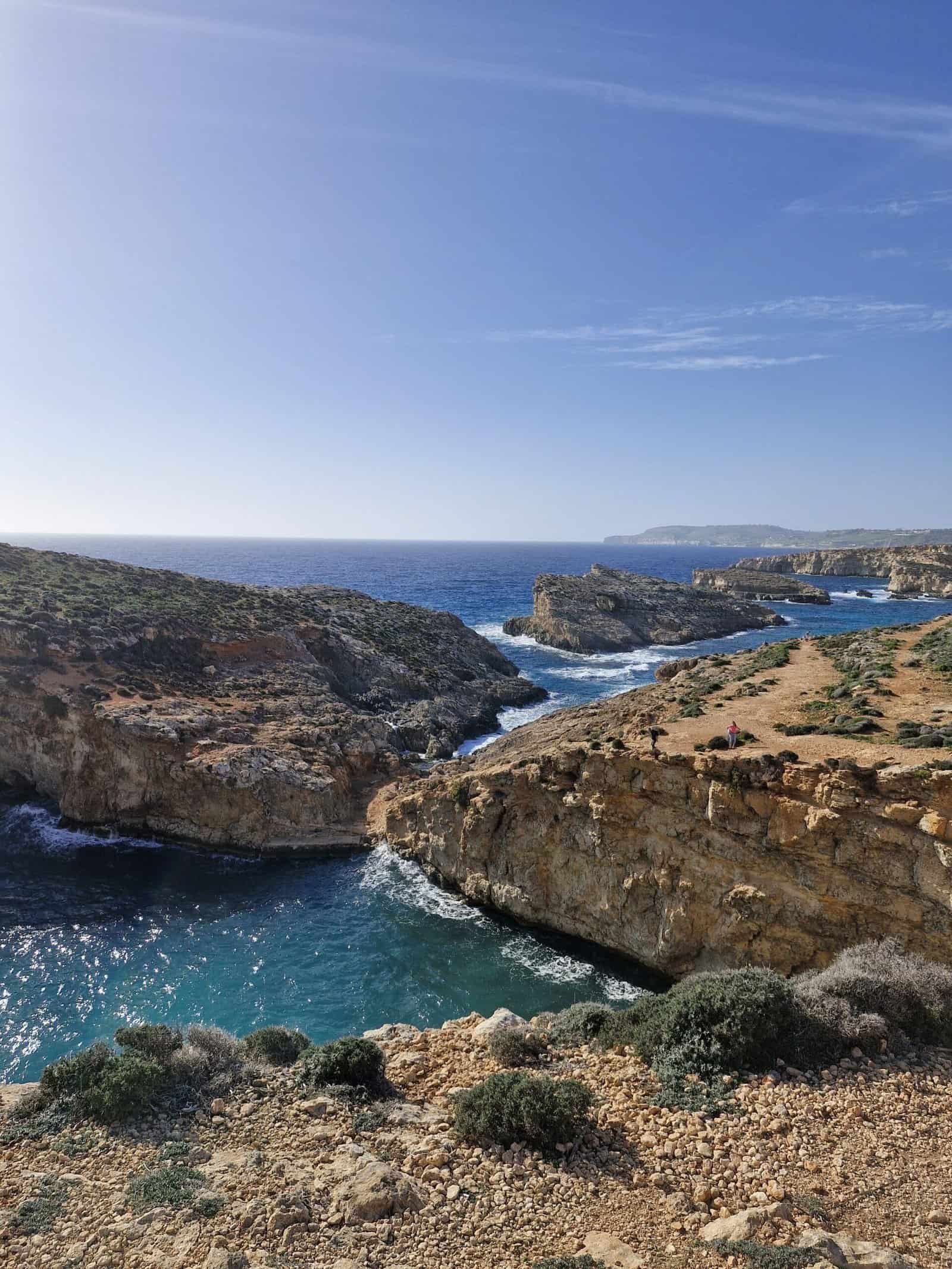 A blue-green sea with limestone cliffs.