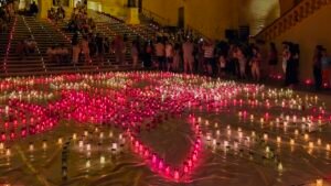 Hundreds of candles arranged in a flower pattern in front of Cathedral steps.