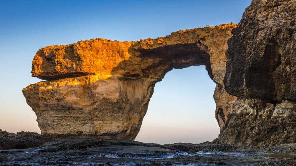 Natural arch reflecting in water.
