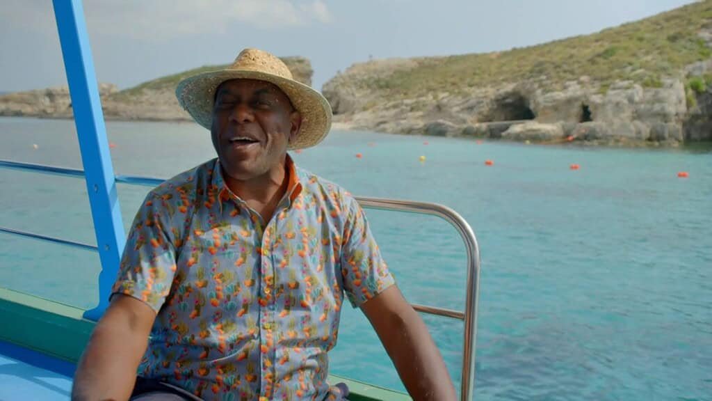 Man in a boat near coastline.