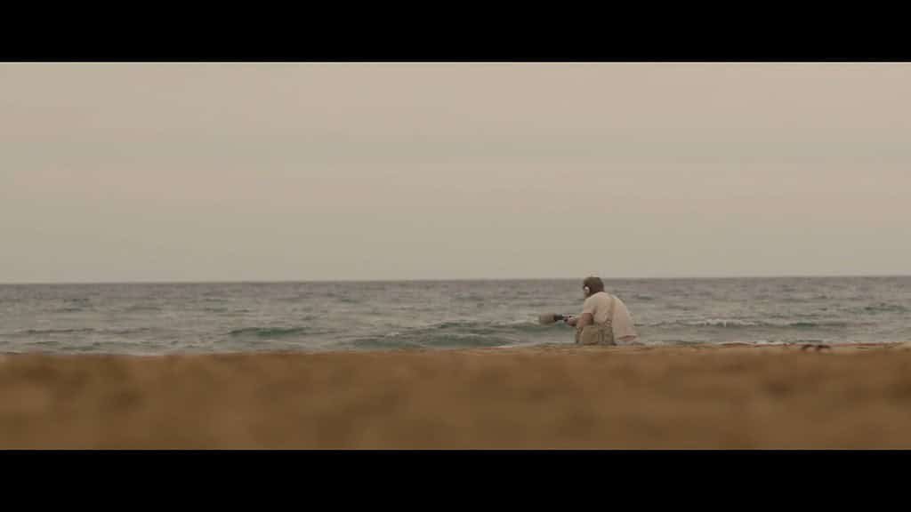Man fishing by the calm sea.