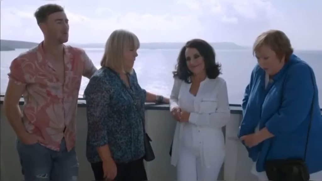 Group by the sea, enjoying scenery.