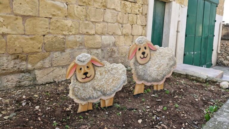 Two cheerful sheep decorations in garden.