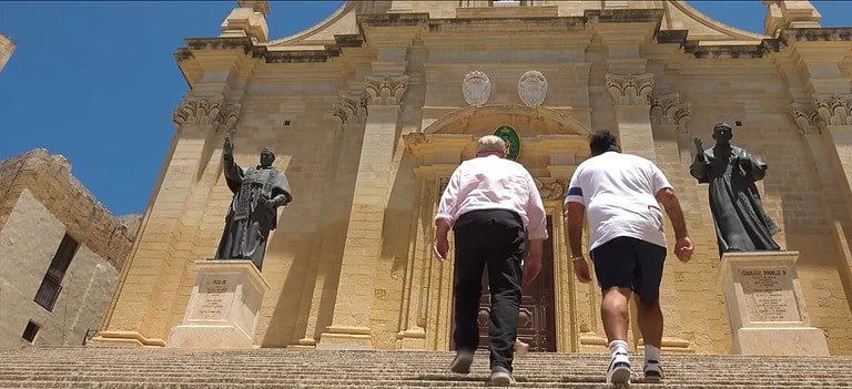 Two men ascending grand stone steps.