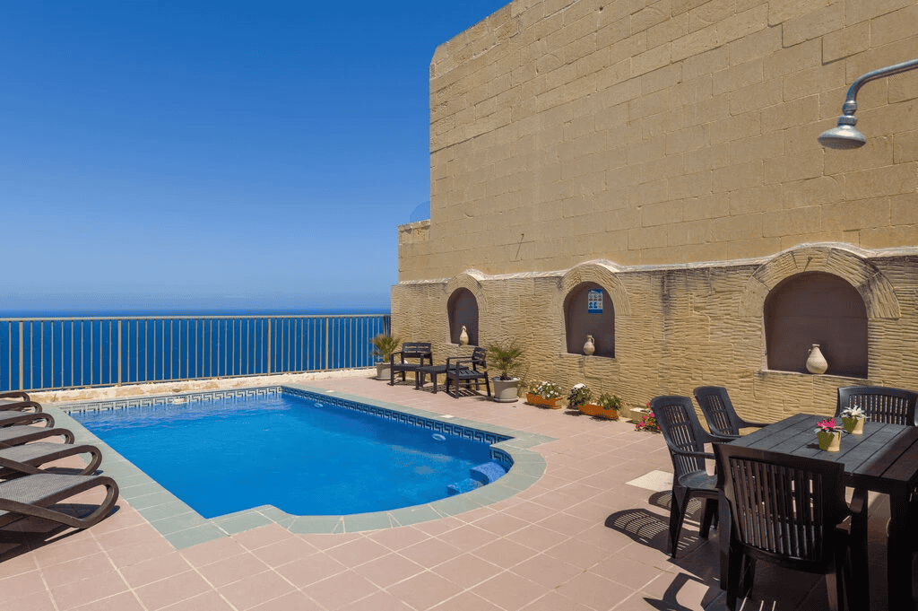 The terrace of Haven Farmhouse, Gozo with a pool and sea view.