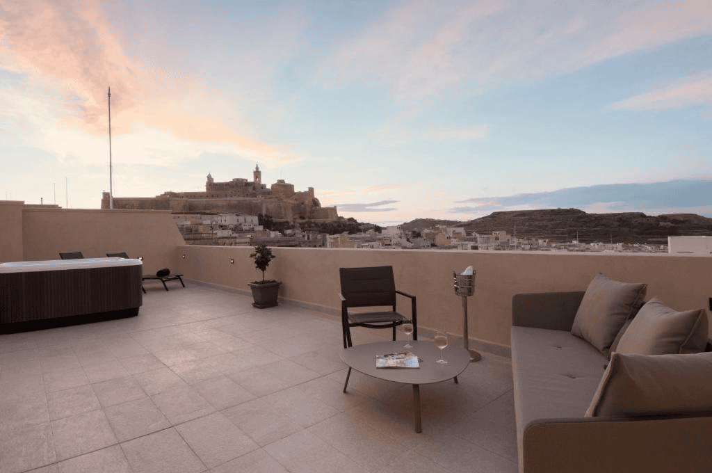 The Duke Boutique Hotel's terrace with a hot tub, sofa, low table and chair and a view of the Citadel.