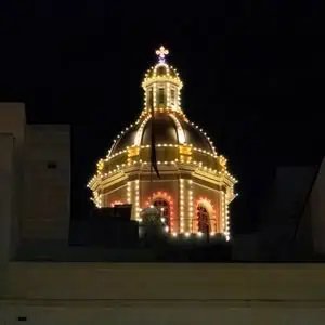 A beautifully lit dome against a night sky, showcasing Maltese architecture.