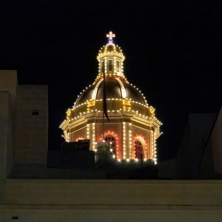 A beautifully lit dome against a night sky, showcasing Maltese architecture.